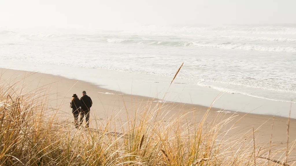 Couple walking on the beach in Lincoln City, Oregon.